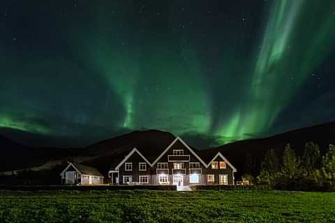 Skálakot exterior with northern lights