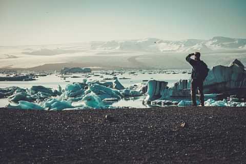 370 man explorer lookig at jokulsarlon lagoon iceland PAQMY5 L